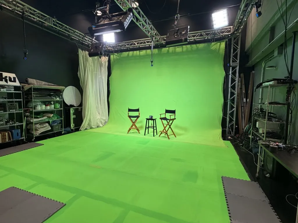 VTOKU's green-screen sound stage, with overhead lighting truss and director's chairs